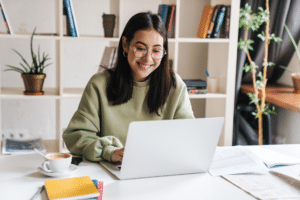 woman smiling at laptop while learning